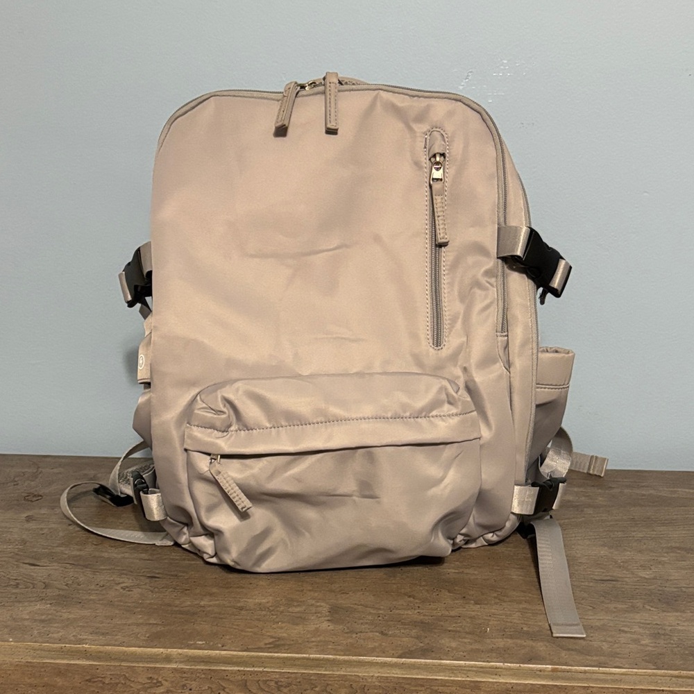 Stylish Light Grey Backpack, several compartments, one for a laptop, charger.